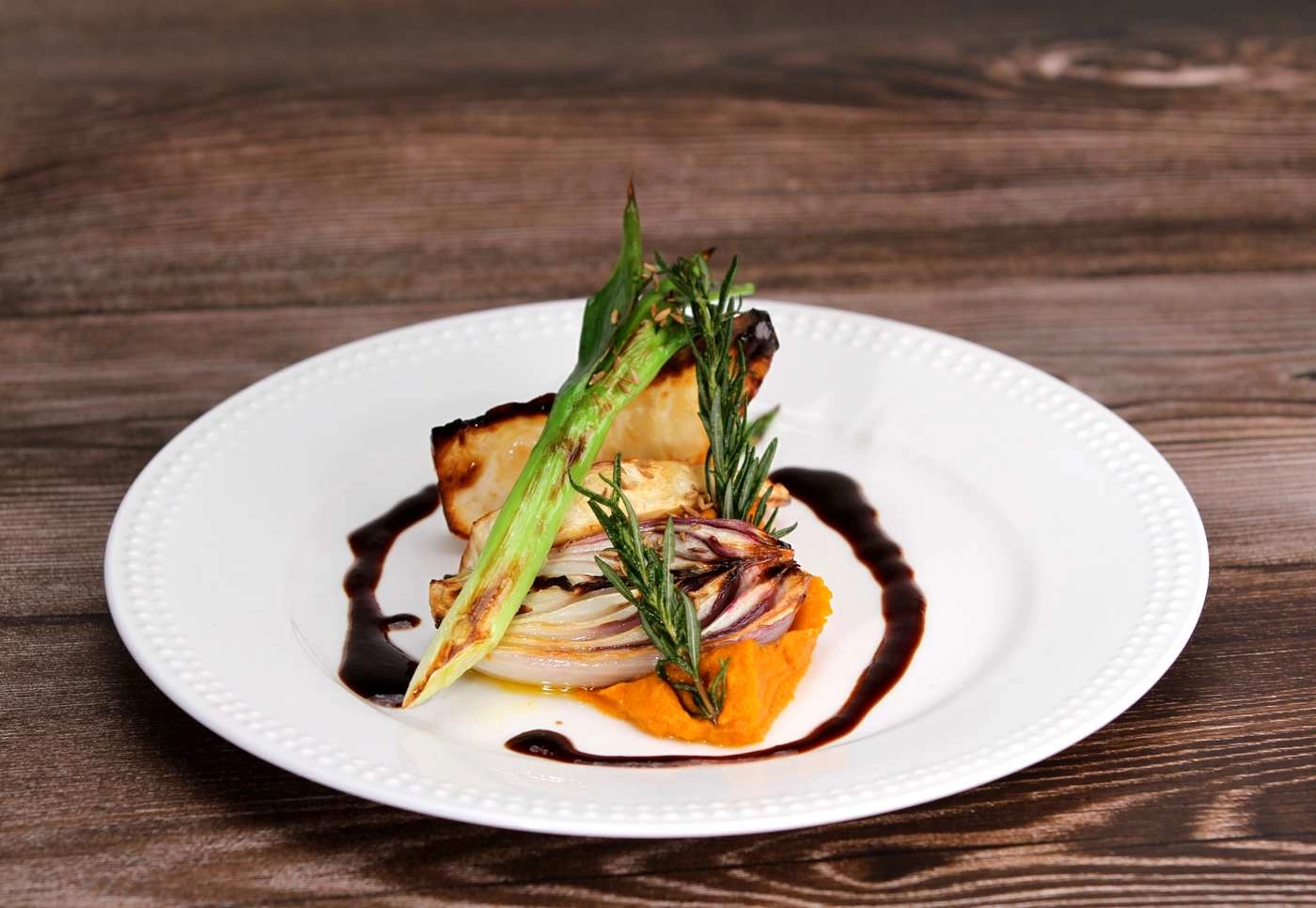 Veganer Hauptgang mit gegrilltem Radicchio und Kürbispüree – Hochzeitsmenü am Tisch von VEINKOST